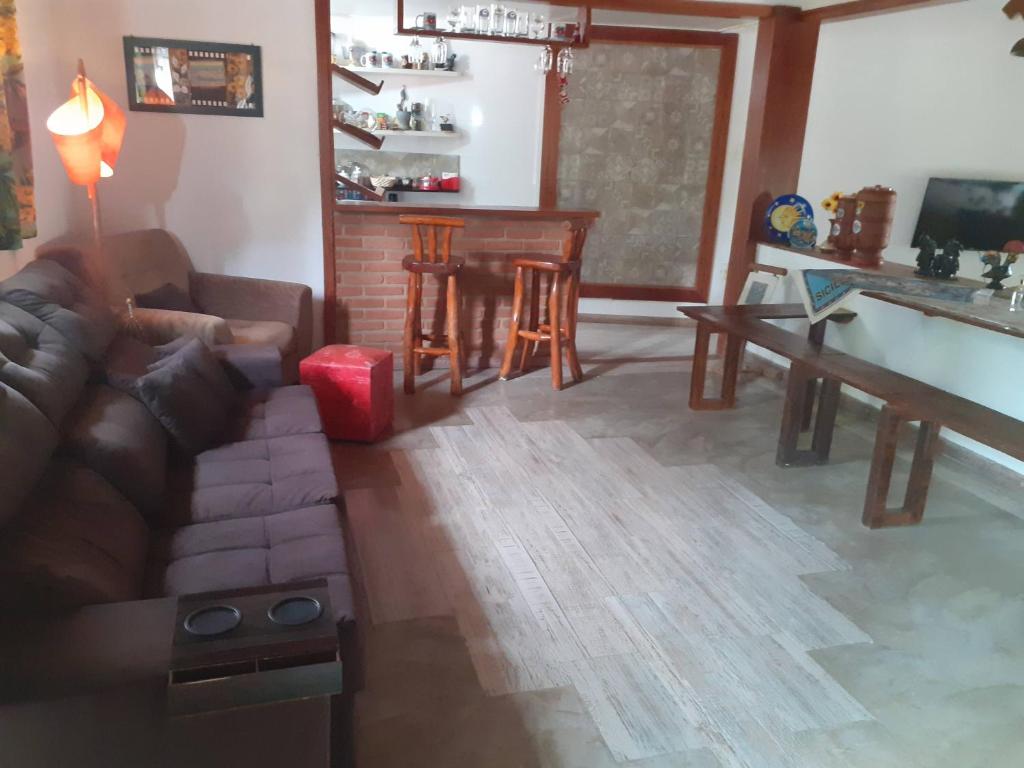 a living room with a couch and a table at Pousada Chalé na Roça Penedo in Penedo