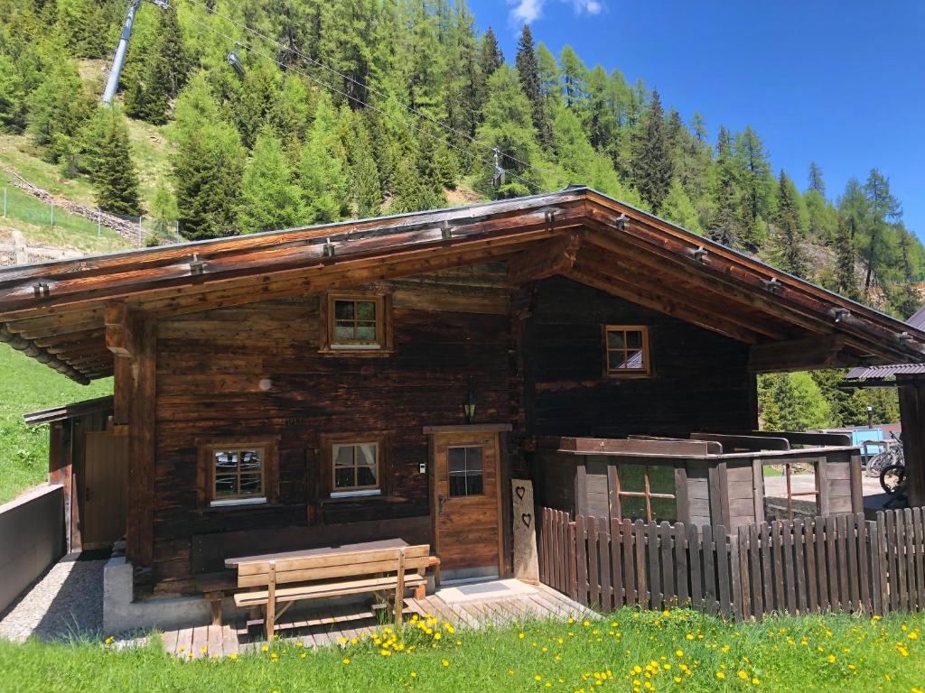 a log cabin with a bench in front of it at Thalers Almhütte in Sölden