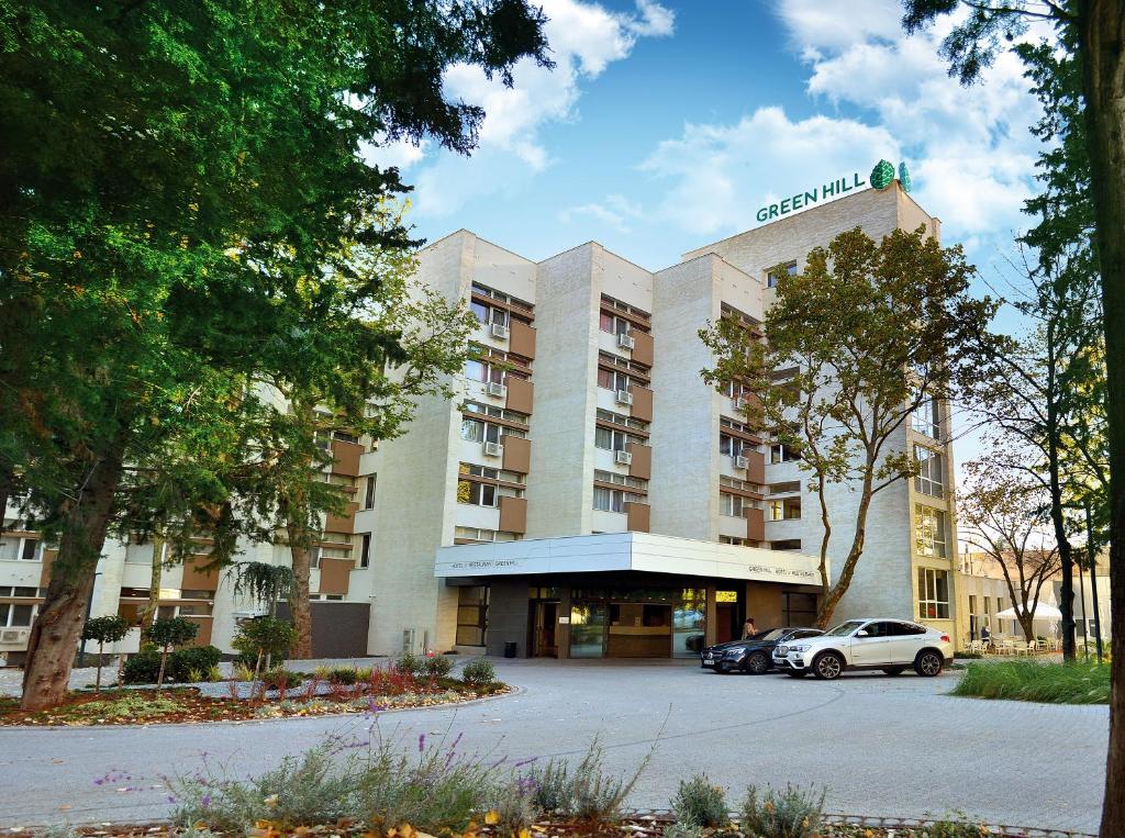 un edificio con un coche aparcado delante de él en Green Hill Hotel en Stara Zagora