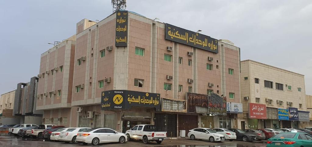 a large building with cars parked in a parking lot at Nawara Al Askary - Al Sulimaniah in Riyadh