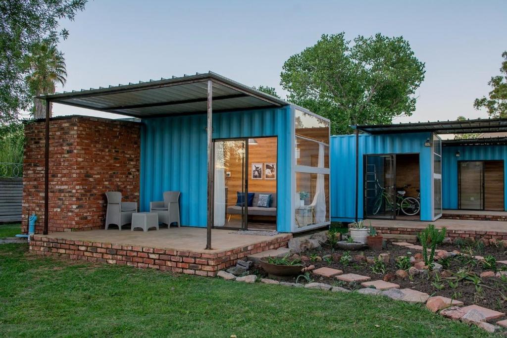 a blue building with a table and chairs in a yard at Studios @ Delver in Parys