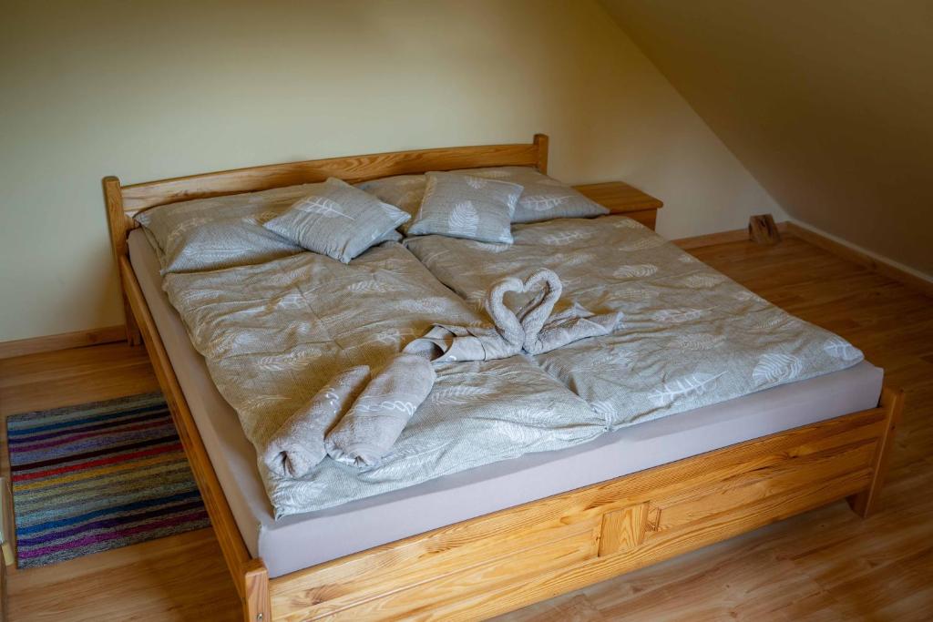 a bed with white blankets and pillows on it at Penzion Zbojník in Terchová