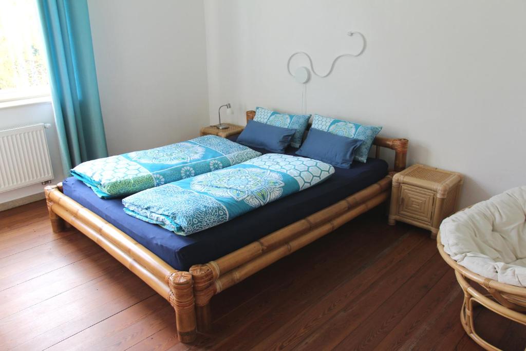 Bett mit blauen Kissen auf einem Zimmer in der Unterkunft Im Bahnhof - Gästezimmer - in Weikersheim