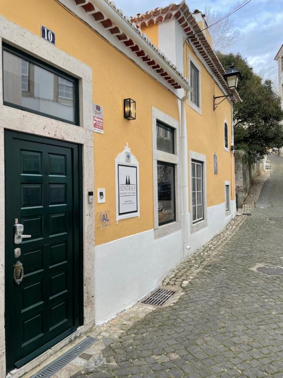 a small building with a door leading to a street at Sintra1012 Boutique Guesthouse in Sintra