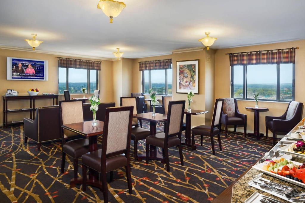 una sala da pranzo con tavoli, sedie e finestre di Sheraton Springfield Monarch Place Hotel a Springfield