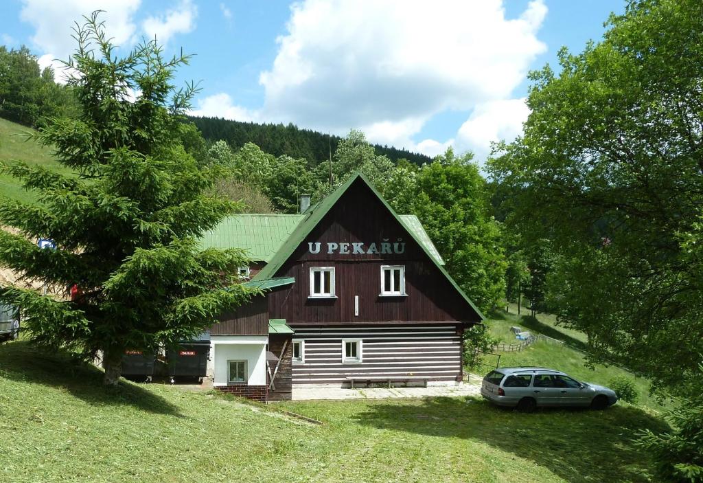 une maison avec une voiture garée devant elle dans l'établissement Horská chata U Pekařů, à Pec pod Sněžkou