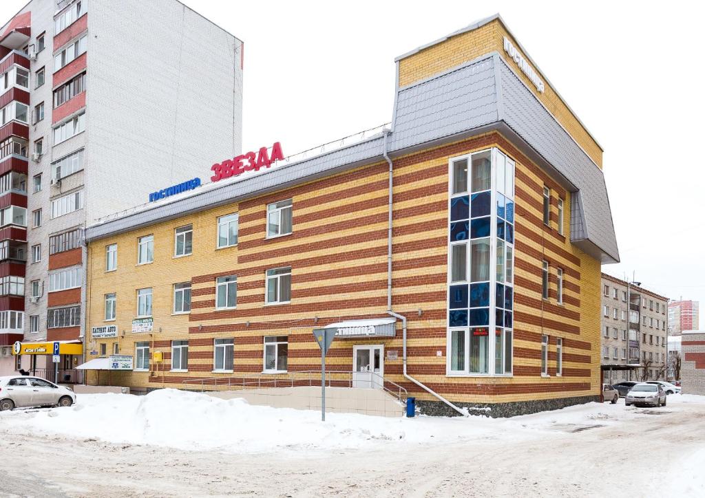 um edifício castanho com uma placa em frente em Hotel Zvezda em Tiumen