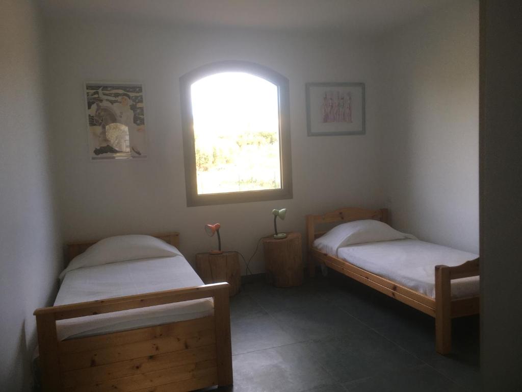 two beds in a room with a window at Le poisson qui recule - Maison et piscine dans parc arboré proche mer in Sanary-sur-Mer