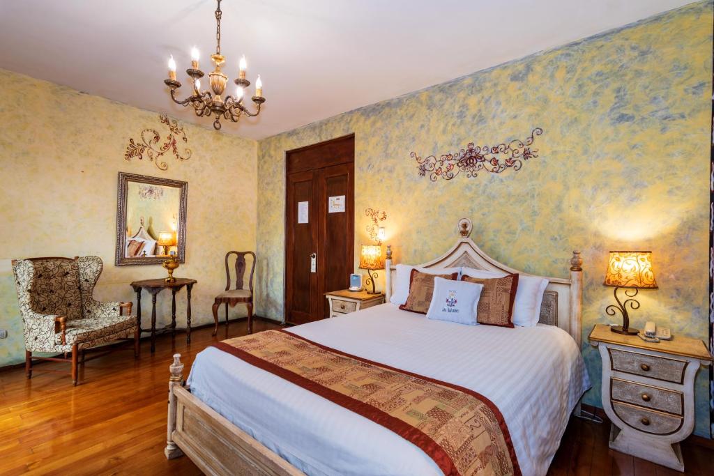 a bedroom with a bed and a chandelier at Hotel Boutique Los Balcones in Cuenca