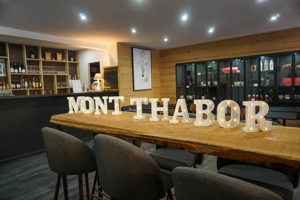 a table in a restaurant with a sign that reads not thatotin at Hôtel Mont Thabor Serre Chevalier in La Salle-les-Alpes