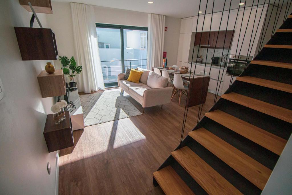 - un salon avec un escalier et un canapé dans l'établissement Apartamentos da Travessa, à Praia da Vitória
