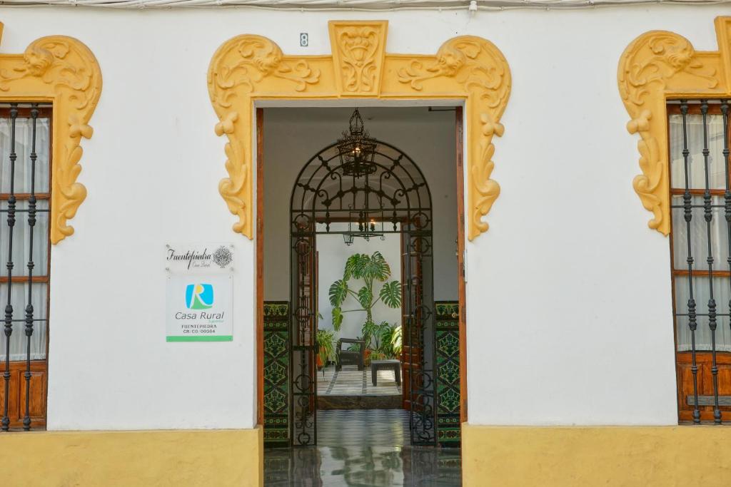 una entrada a un edificio con una puerta abierta en Fuentepiedra Casa Rural Categoría Superior, en Almodóvar del Río