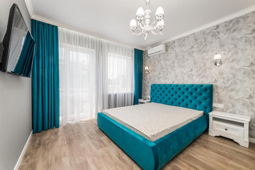 ein Schlafzimmer mit einem blauen Bett und einem Fenster in der Unterkunft 20 Deribasivska Design Apartment in Odessa