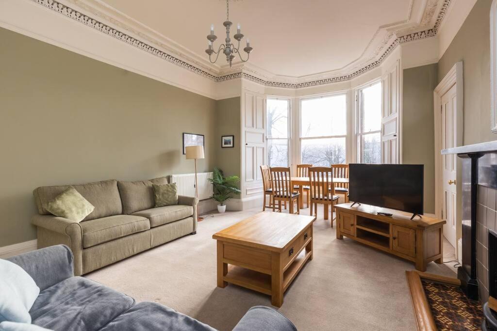 uma sala de estar com um sofá e uma televisão em Stunning 3 Bedroom Flat in Bruntsfield em Edimburgo