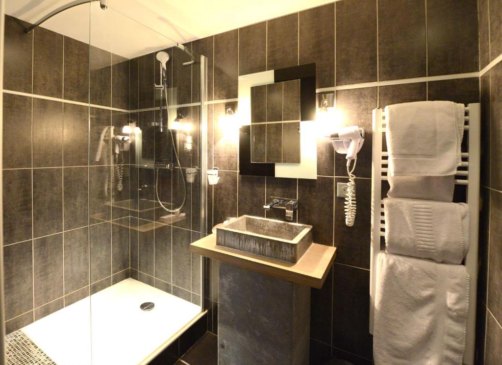 a bathroom with a shower and a sink and a shower at Hostellerie de la Renaissance - Teritoria in Argentan