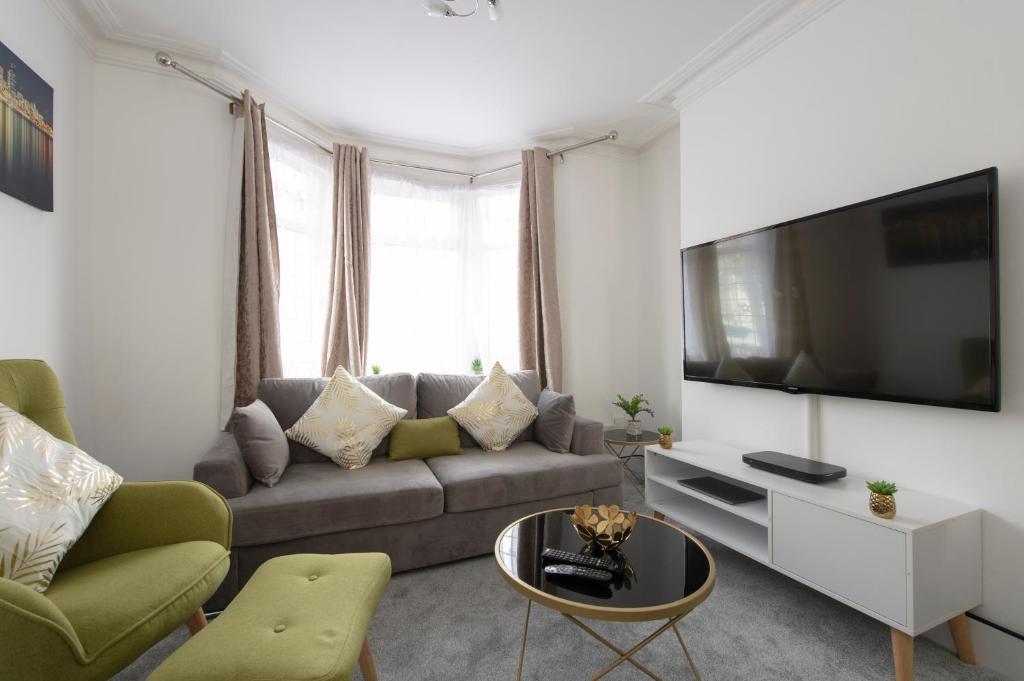 a living room with a couch and a flat screen tv at Fortified Beautiful Three bedroom House in Plumstead