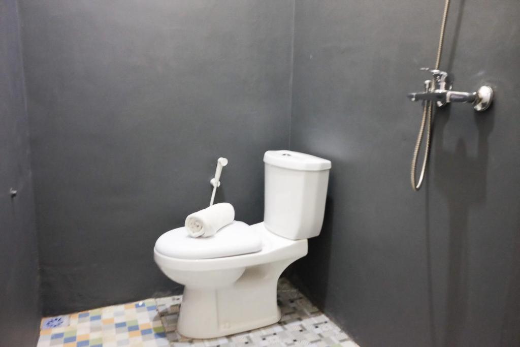 un bagno con un water bianco in una cabina di RedDoorz Syariah near Exit Tol Pemalang Comal 2 a Comal