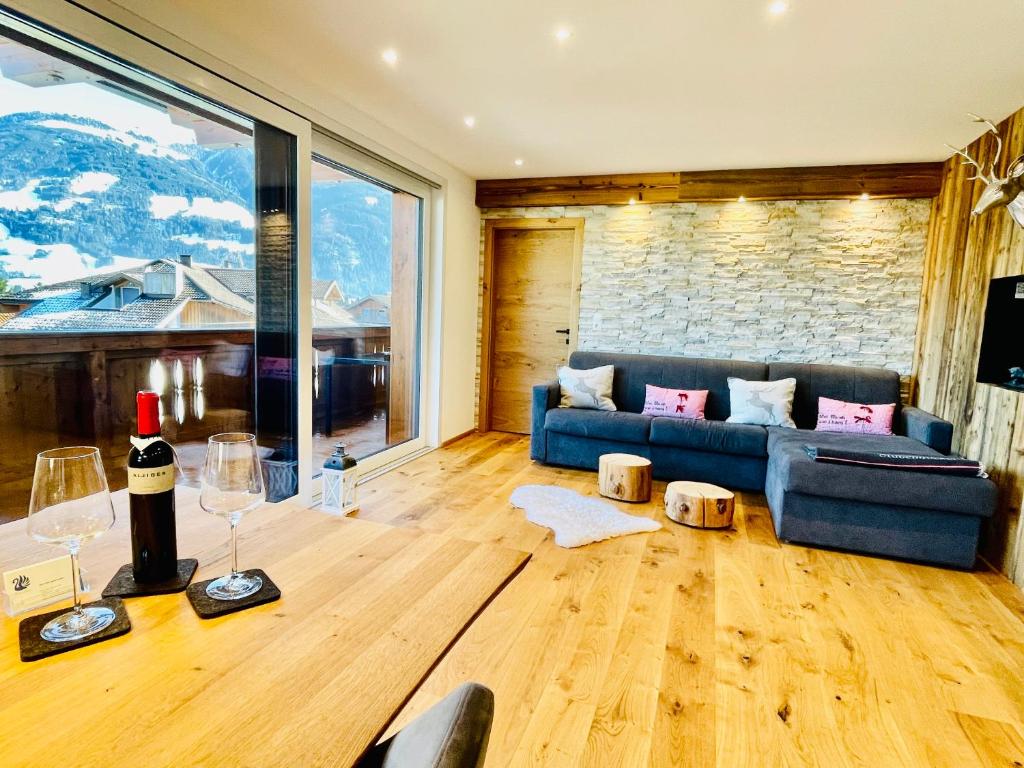 salon z kanapą i stołem z kieliszkami do wina w obiekcie Royal Swan Appartement, Tirol w mieście Fügen