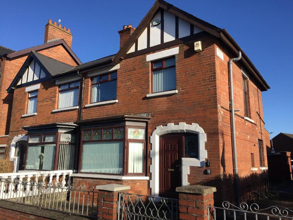 a red brick house with a brown door at Crumlin Road Town House in Belfast