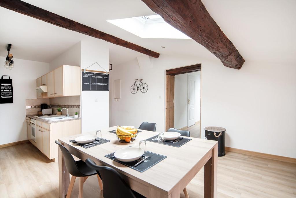 een keuken en eetkamer met een tafel en stoelen bij Appartement cosy et moderne en plein cœur du centre ville in Mâcon