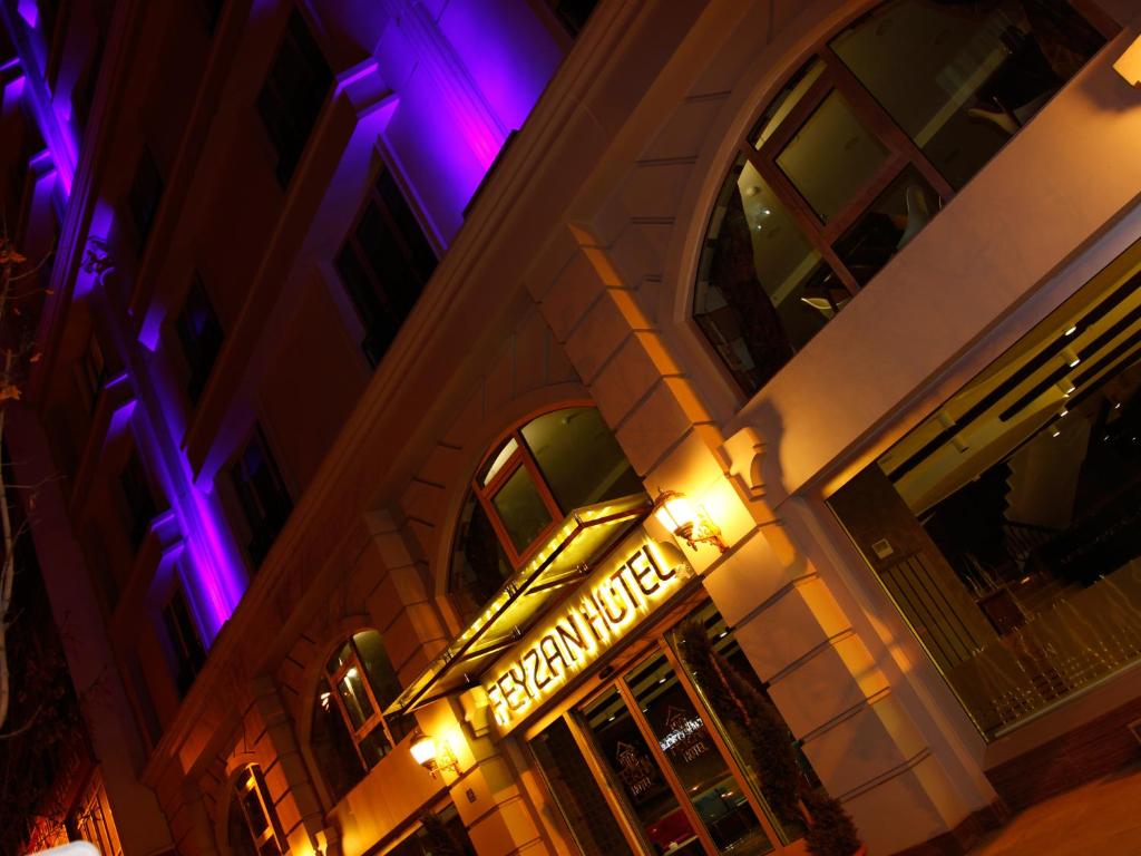 CorumにあるFeyzan Hotelの紫色と紫色の灯りが灯る建物