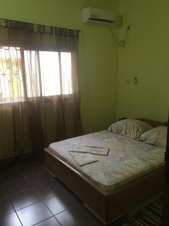 Tempat tidur dalam kamar di Vicky Appartements Palmengarten Douala Maképè Belavie
