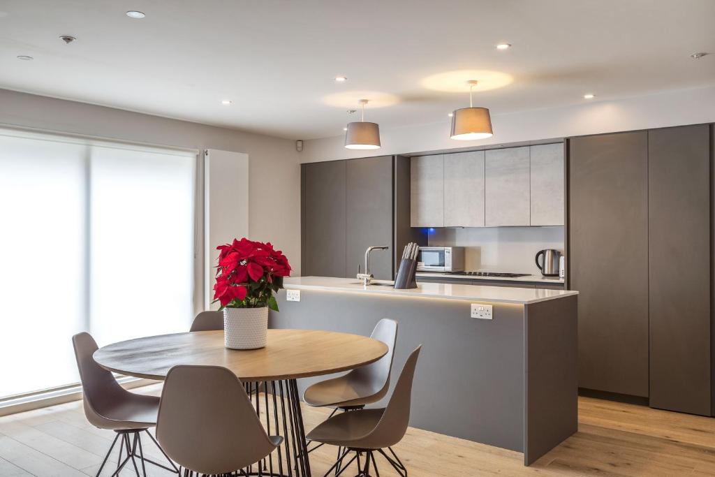 a kitchen with a table and chairs and a kitchen with a counter at PickThePlace family house in West Kensington in London