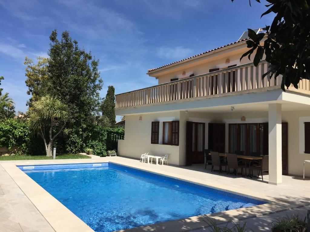 eine Villa mit einem Pool vor einem Haus in der Unterkunft Villa Antonia in Sa Coma