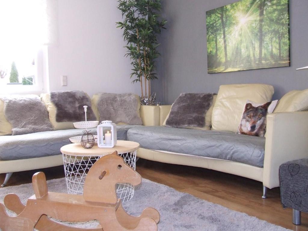a living room with two couches and a dog on the couch at Ferienwohnung Hochwald - im Herzen des Saarlandes in Quierschied