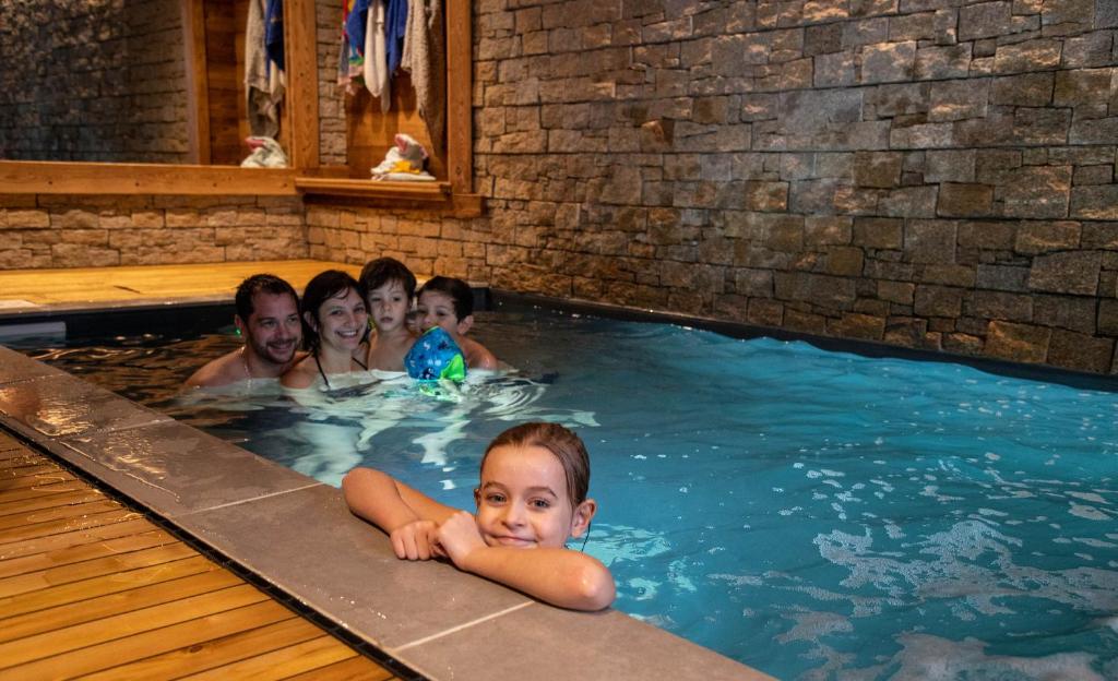 een groep mensen in een zwembad bij Gîte 5* piscine intérieure, sauna, à 20 mins des pistes de ski, à 300 m d’un Lac in Saulxures-sur-Moselotte