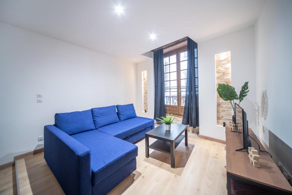 a living room with a blue couch and a table at Appartement Contemporain au coeur du centre ville in Mâcon