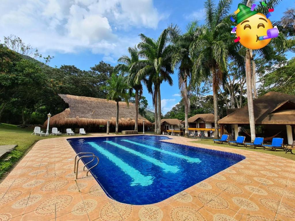a resort swimming pool with palm trees and a resort at Finca Hotel La Consentida Escondida in San Jerónimo