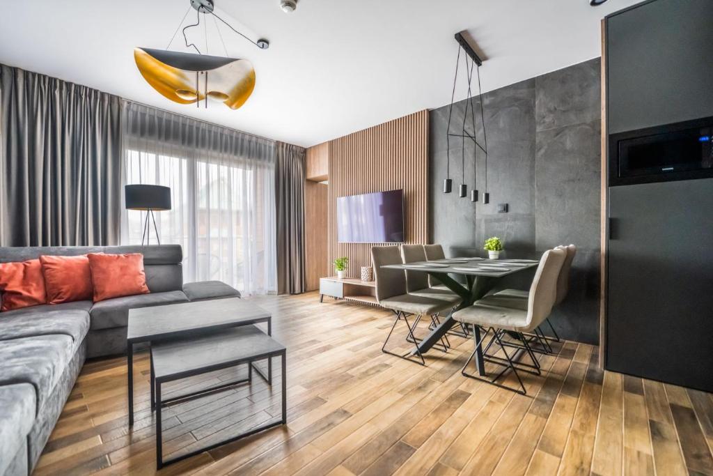 uma sala de estar com um sofá e uma mesa em StoneHill24 - Apartament & Spa em Szklarska Poręba