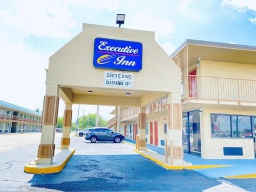 a gas station with a blue sign on it at Executive Inn in Kingsville