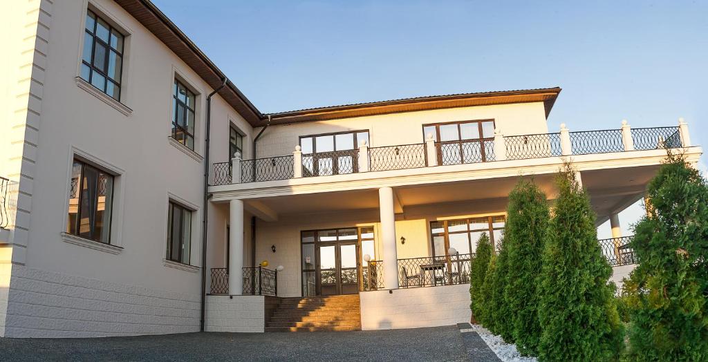 a large white house with a balcony on it at Colinele Aurii Cimislia in Cimişlia