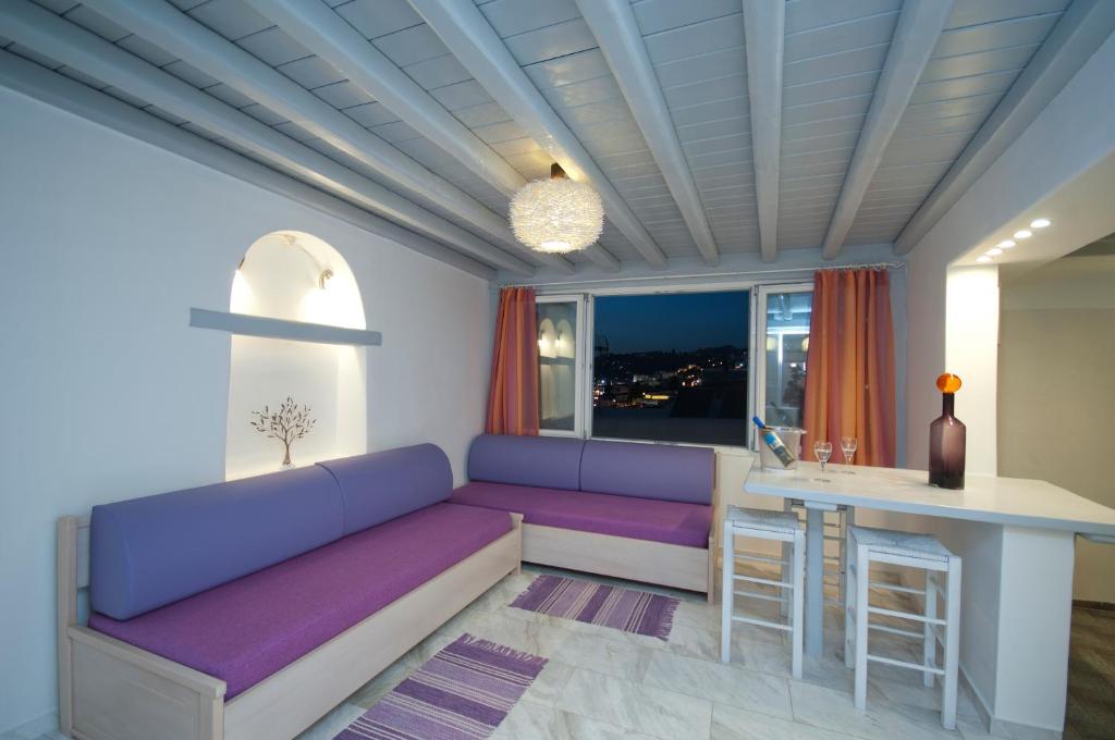 a living room with a purple couch and a table at Mykonos Marina in Mikonos