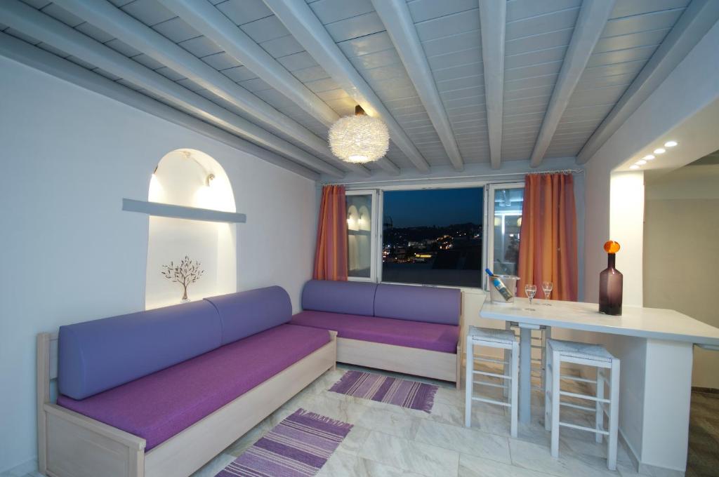 Una sala de estar con un sofá morado y una mesa. en Mykonos Marina, en Mykonos ciudad