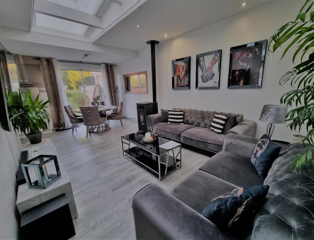uma sala de estar com um sofá e uma mesa em Oasis Citadine Terrasse intime jardin privatif en plein centre ville 70m2 em Cambrai