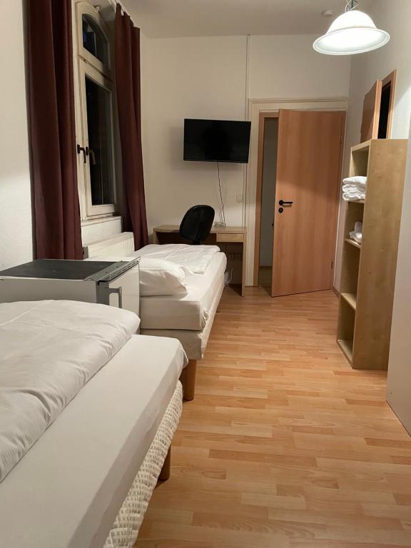 a hotel room with two beds and a television at Relax Hotel-Ludwigshafen in Ludwigshafen am Rhein