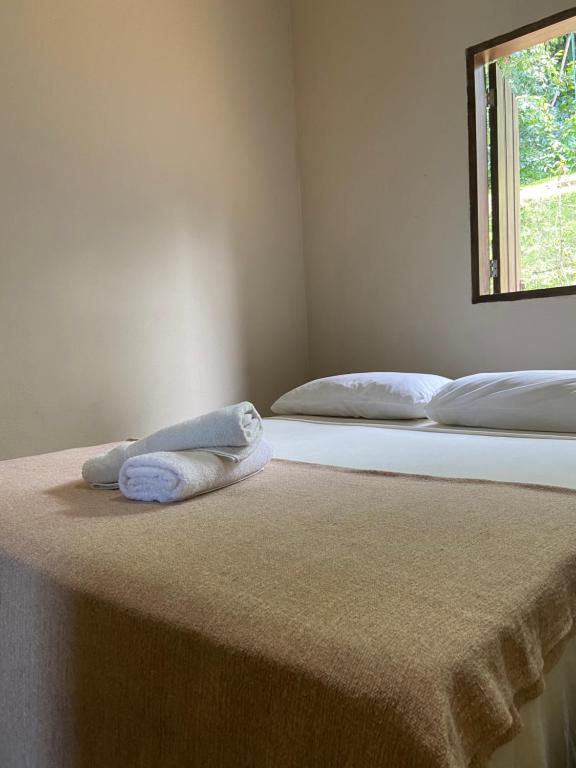 two beds in a room with a towel on the bed at Casa em Paraty, piscina com vista para o mar in Paraty