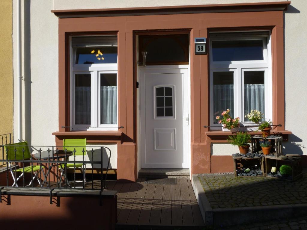 ツェルティンゲン・ラハティグにあるMoselferienhaus-Zeltingenの白いドアと窓と椅子が備わる家