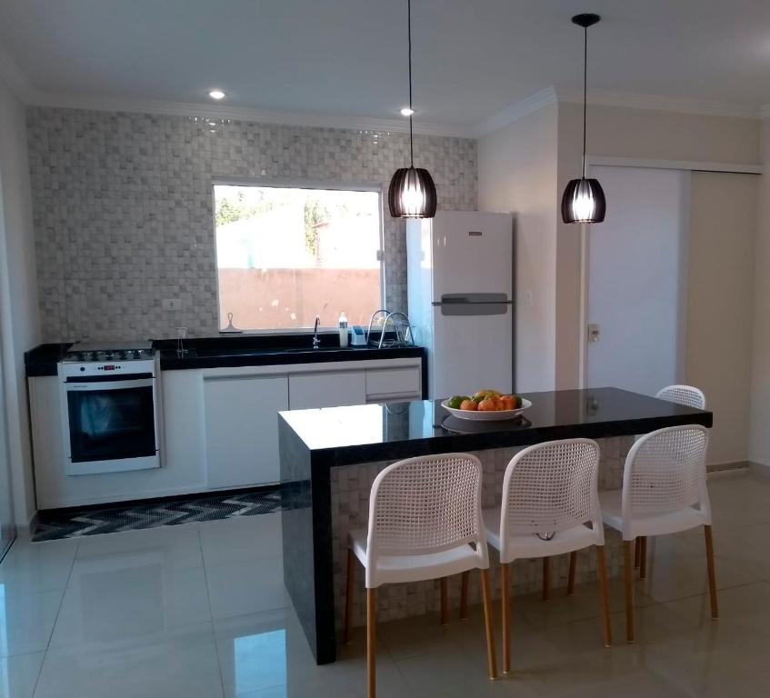 a kitchen with a table with chairs and a counter top at Condomínio Vila da Praia em São José - Maragogi in São José da Coroa Grande