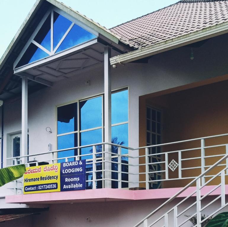 a house with a balcony with signs on it at Hiremane Residency in Sringeri