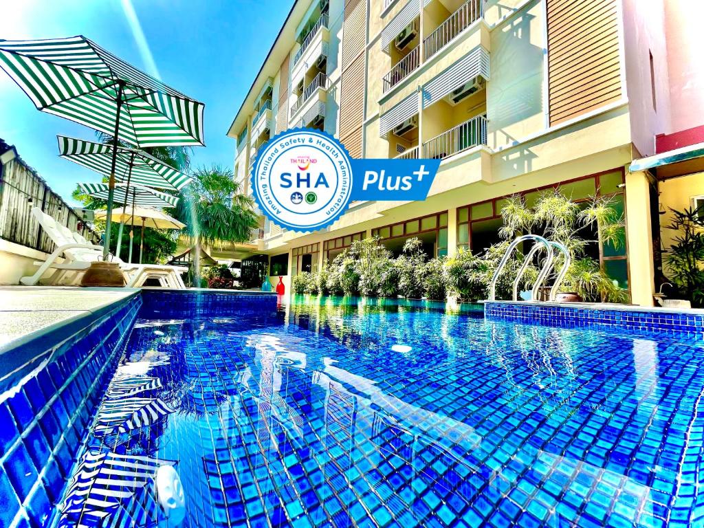 a swimming pool in front of a hotel at Smile Hua-Hin Resort - SHA Plus in Hua Hin