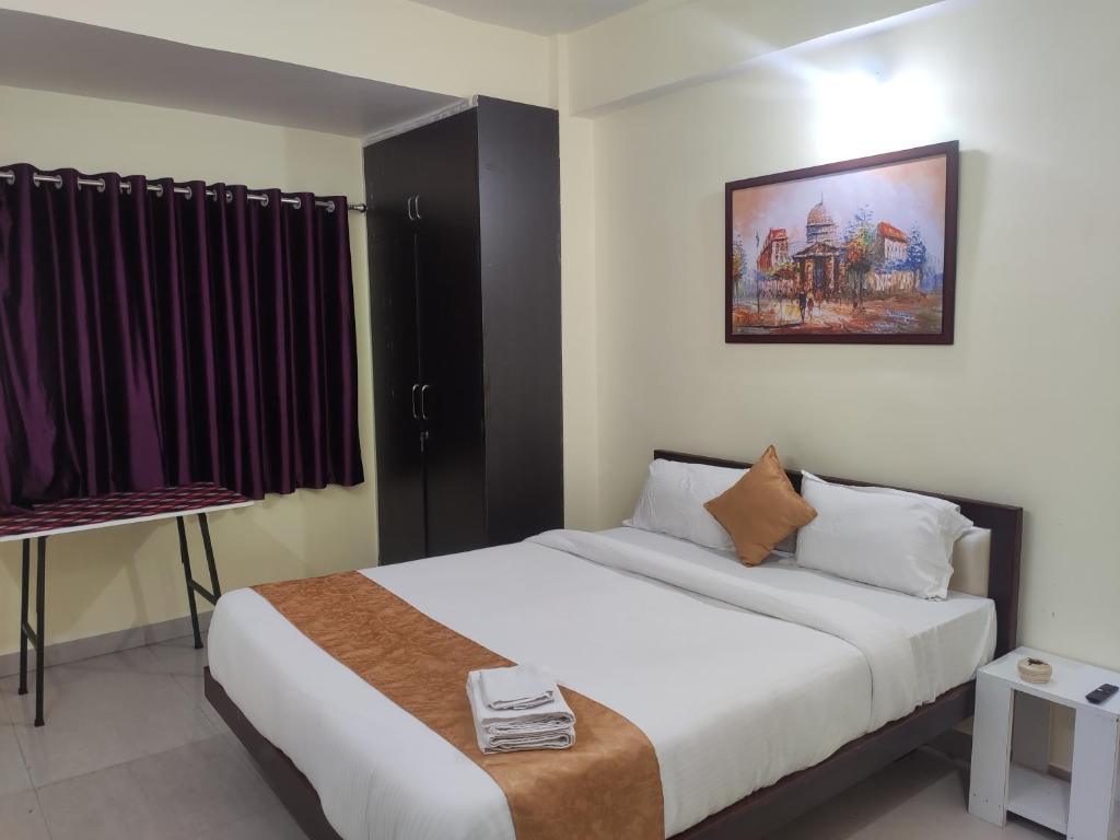 Un dormitorio con una gran cama blanca y una ventana en StayVilla Royal, en Ranchi