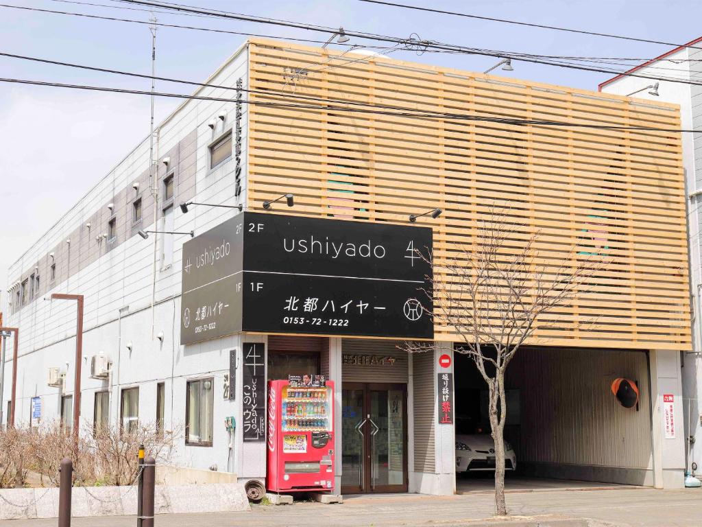 a building with a sign on the front of it at Guesthouse ushiyado in Naka-shibetsu