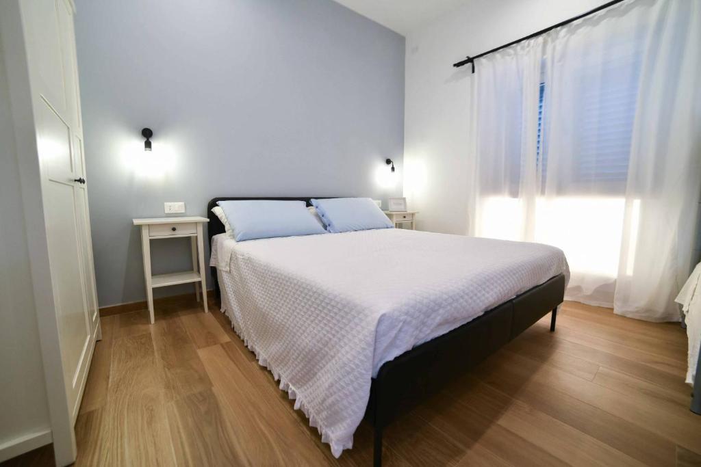 a white bedroom with a bed and a window at La Caletta Bed and Breakfast in Torre Santa Sabina