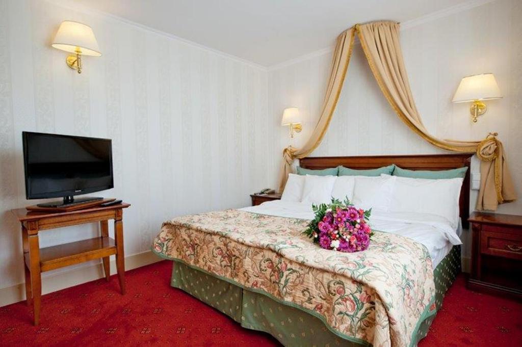 a hotel room with a bed with a flower arrangement on it at Hotel Mazurkas in Ożarów Mazowiecki
