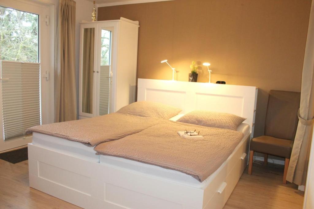Grönwohldshorst的住宿－Landhaus Lippmann Whg2，卧室配有白色的床和椅子