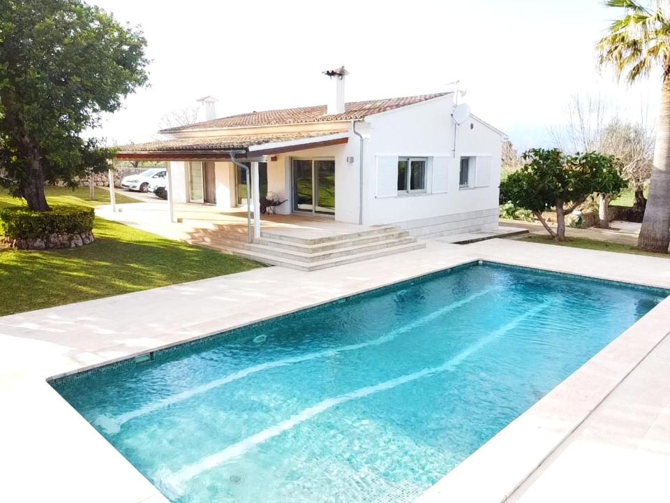 a swimming pool in front of a house at Mallorca Villa Bon Aire in Llubí